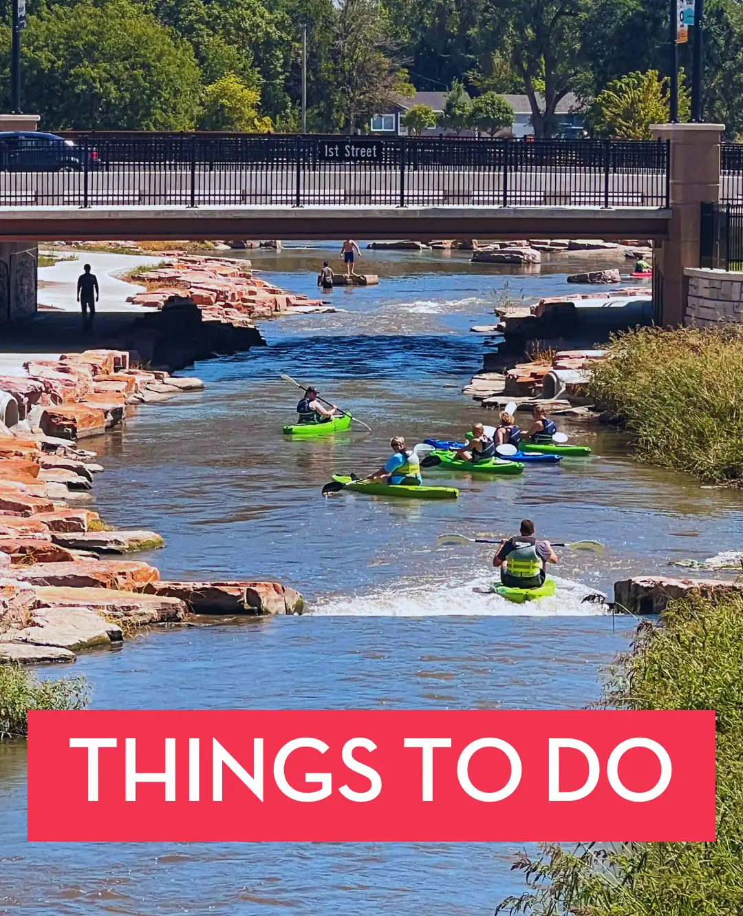 People kayaking along the river beneath the 1st Street bridge with a “Things to Do” banner.